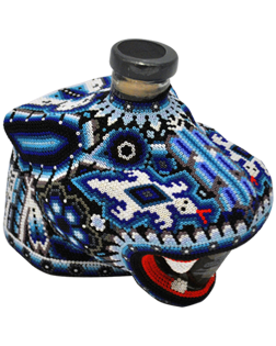 Image of a bottle of Chaquira Blanco Tequila with its colorful jaguar deign, featuring colors of blue, white, and red.