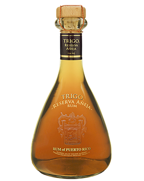 Image of a bottle of Trigo Ron Reserva Añeja Rum featuring a sleek design with a clear label and gold accents.